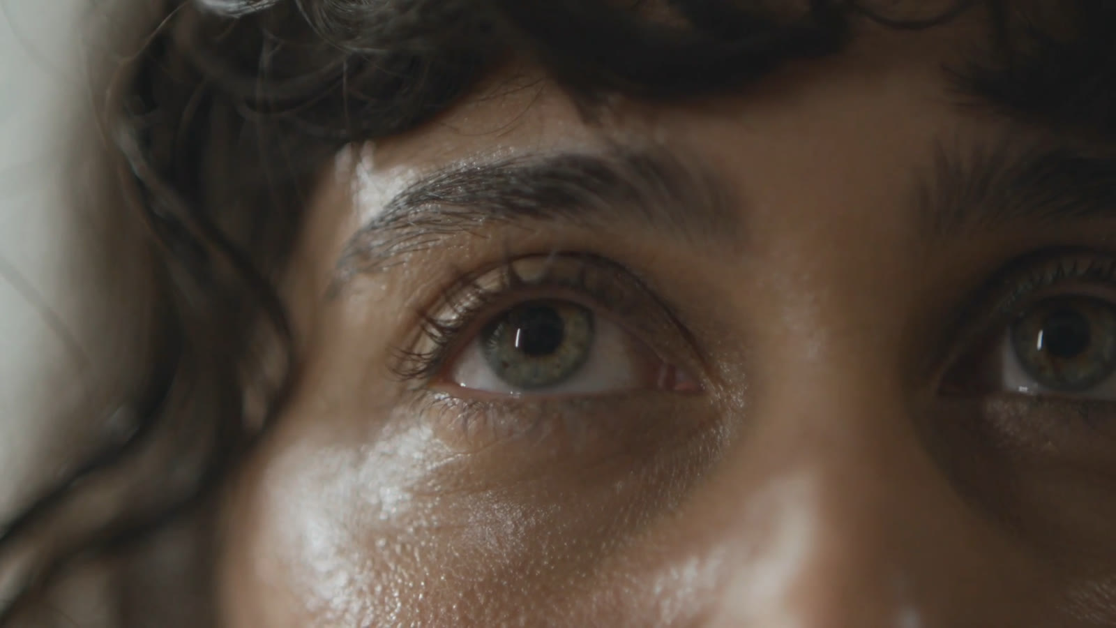 Extreme macro of green eyes, sweat on skin