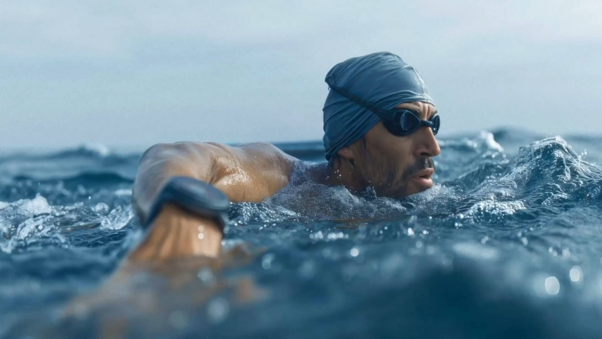 An open-water swimmer mid-stroke, smartwatch on his wrist