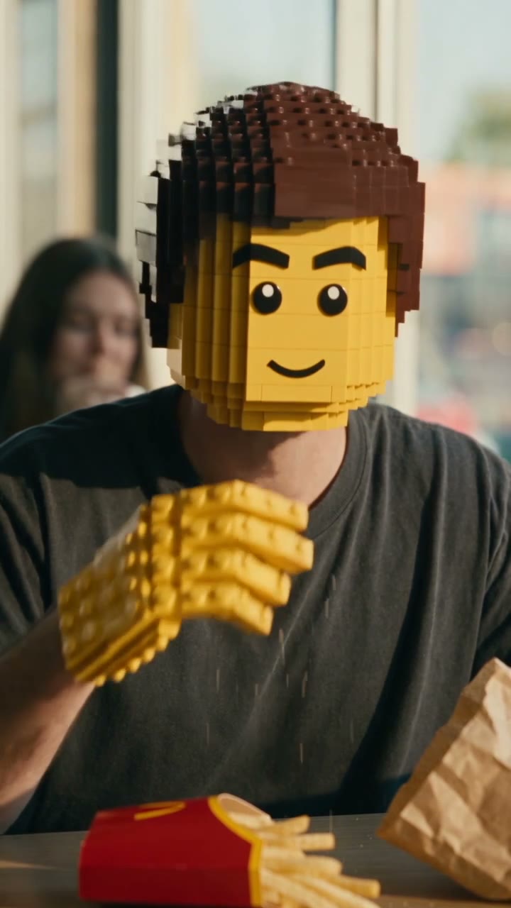 A diner's head has become a LEGO minifigure head mid-meal