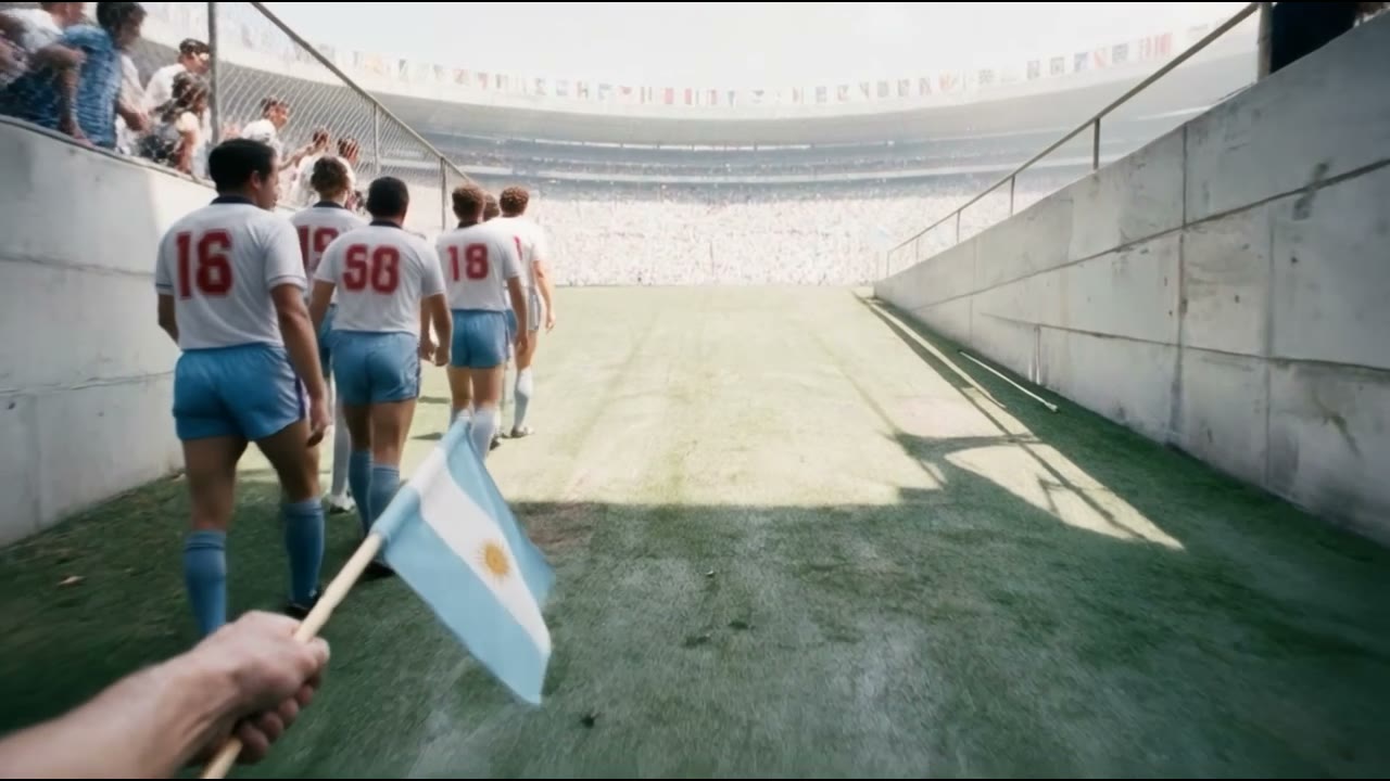 Point of view from the Azteca tunnel: a hand holding an Argentine flag behind the England team
