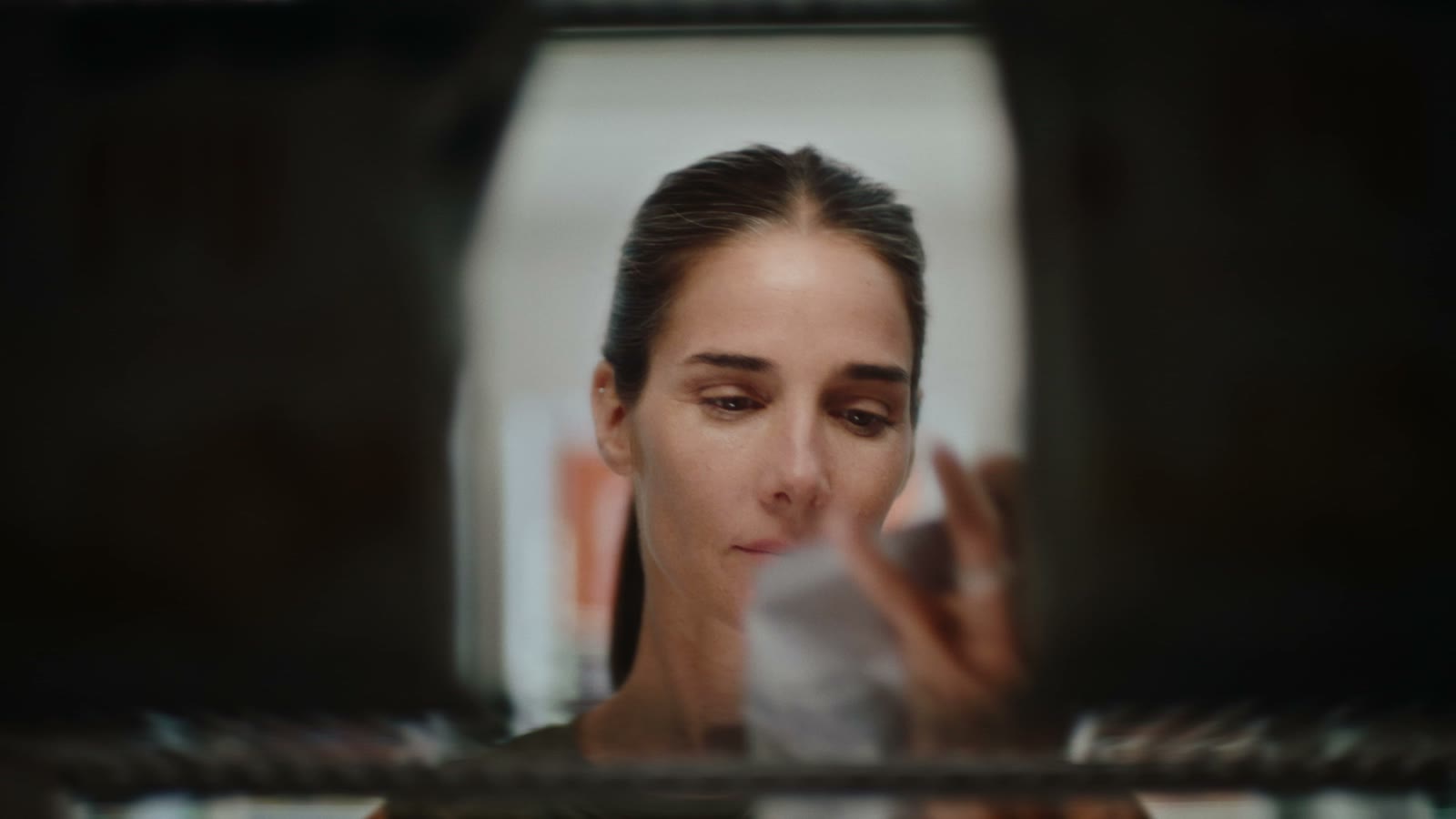 Juana Viale browsing the station shop, seen through shelving